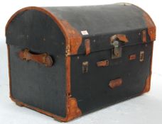 A late 19th Century Victorian domed top travelling trunk having an ebonised canvas body with brown