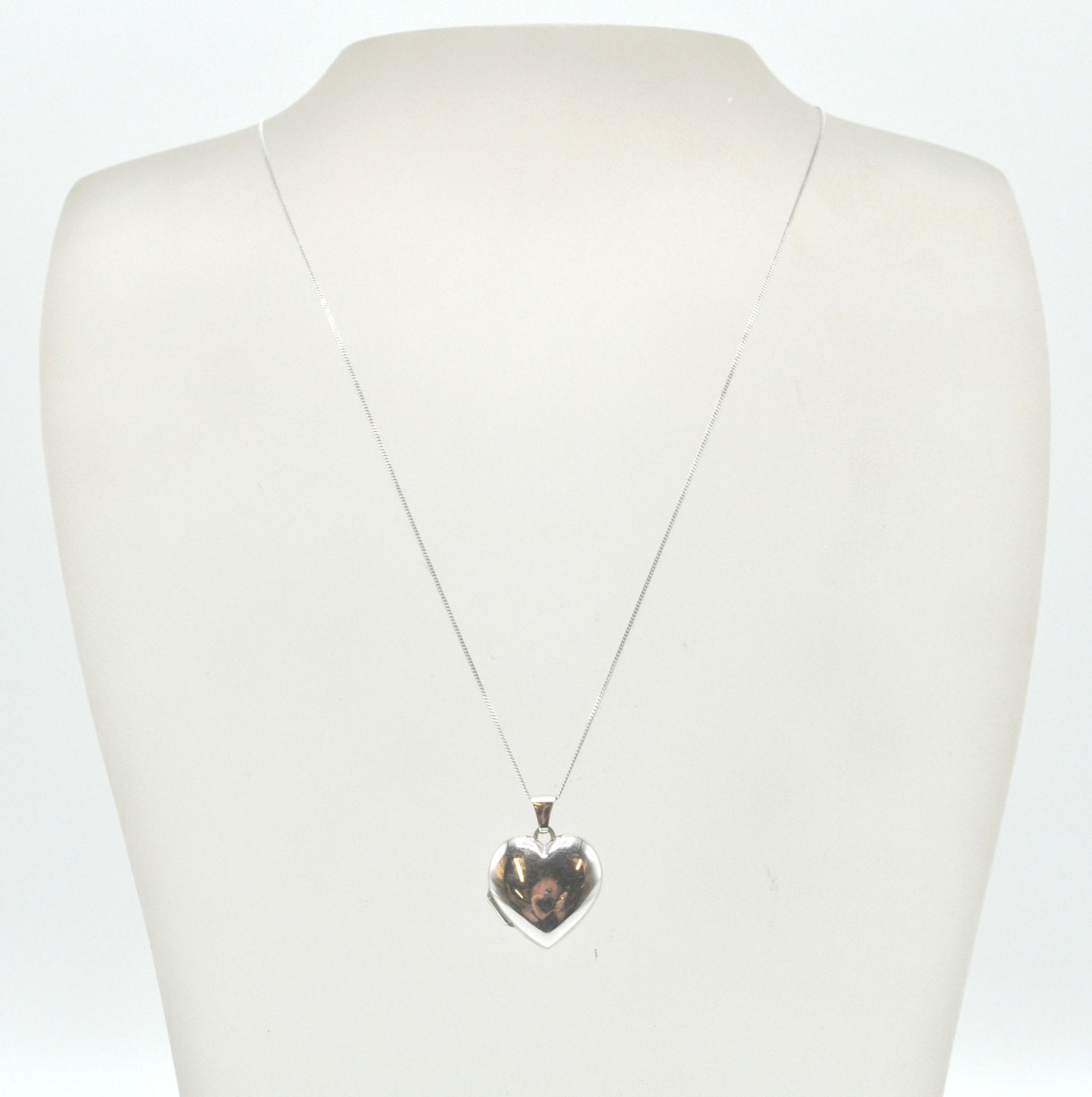 A 9ct white gold heart pendant locket and back chain. The fine linked necklace chain with c-clasp.