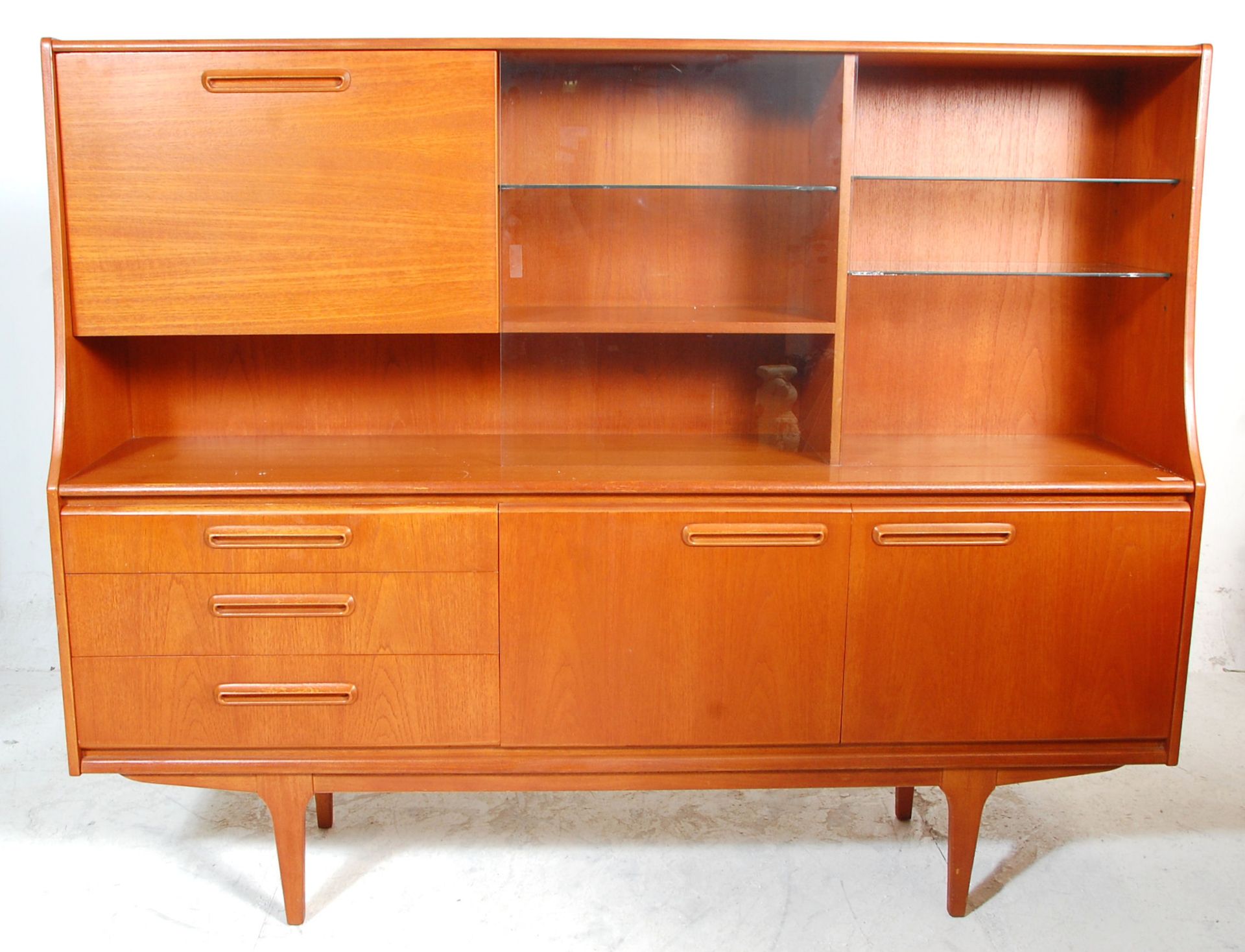 A retro mid 20th Century teak wood sideboard / highboard having a drop down cocktail cabinet to