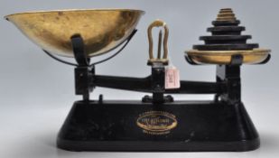 A good pair of vintage cast iron shop weighing scales finished in black having brass trays atop