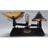 A good pair of vintage cast iron shop weighing scales finished in black having brass trays atop