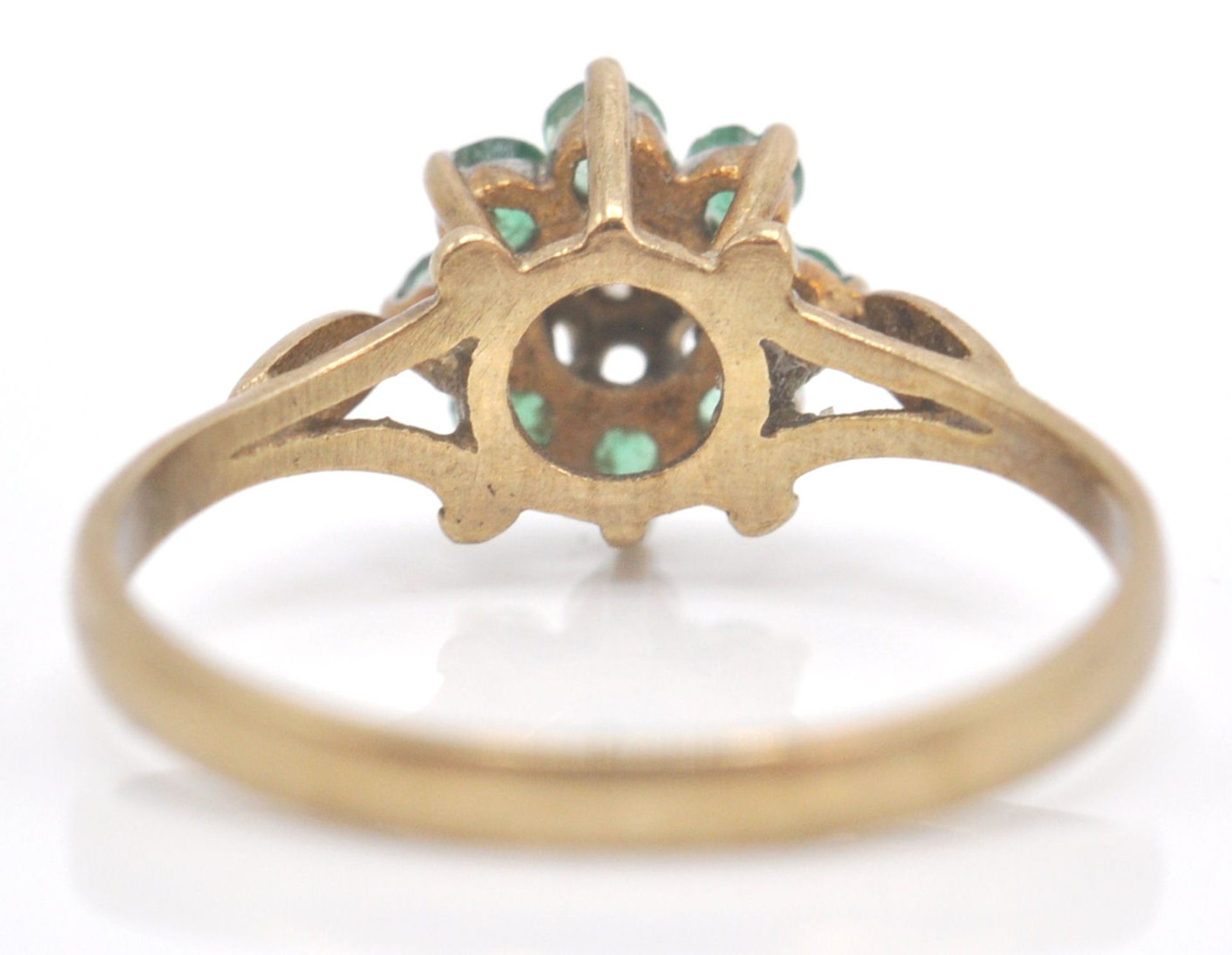 A 9ct gold emerald and diamond cluster ring. The ring with central  mixed cut diamond within a - Bild 4 aus 7