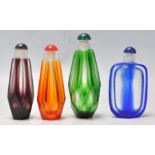 A set of 4 vintage faceted glass perfume bottles in various colours. Measures 9 cm long.
