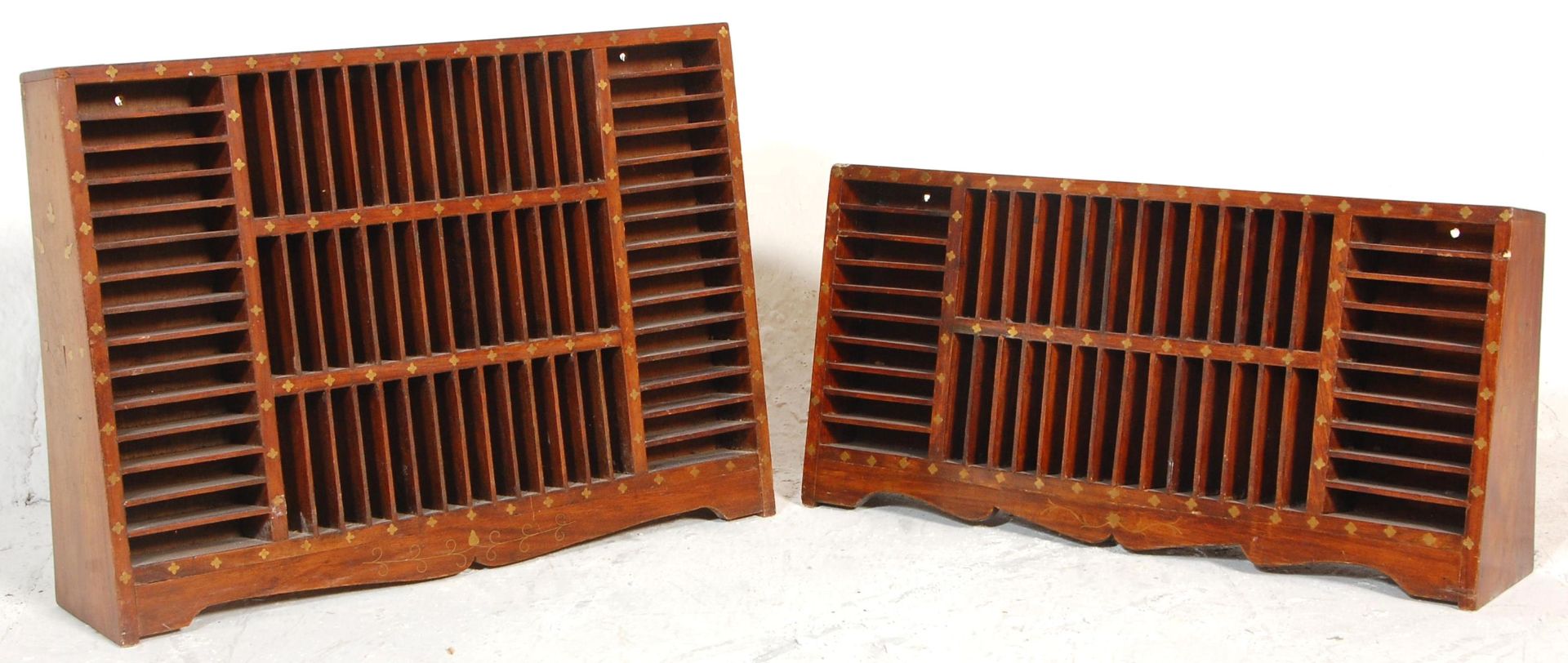 Two inlaid Indian hardwood tape racks having vertical and horizontal slots with decorative brass