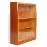 A vintage retro mid 20th Century bookcase having two shelves within, both having glass sliding doors