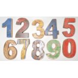 A set of vintage retro wooden signage numbers each having weathered different coloured paintwork