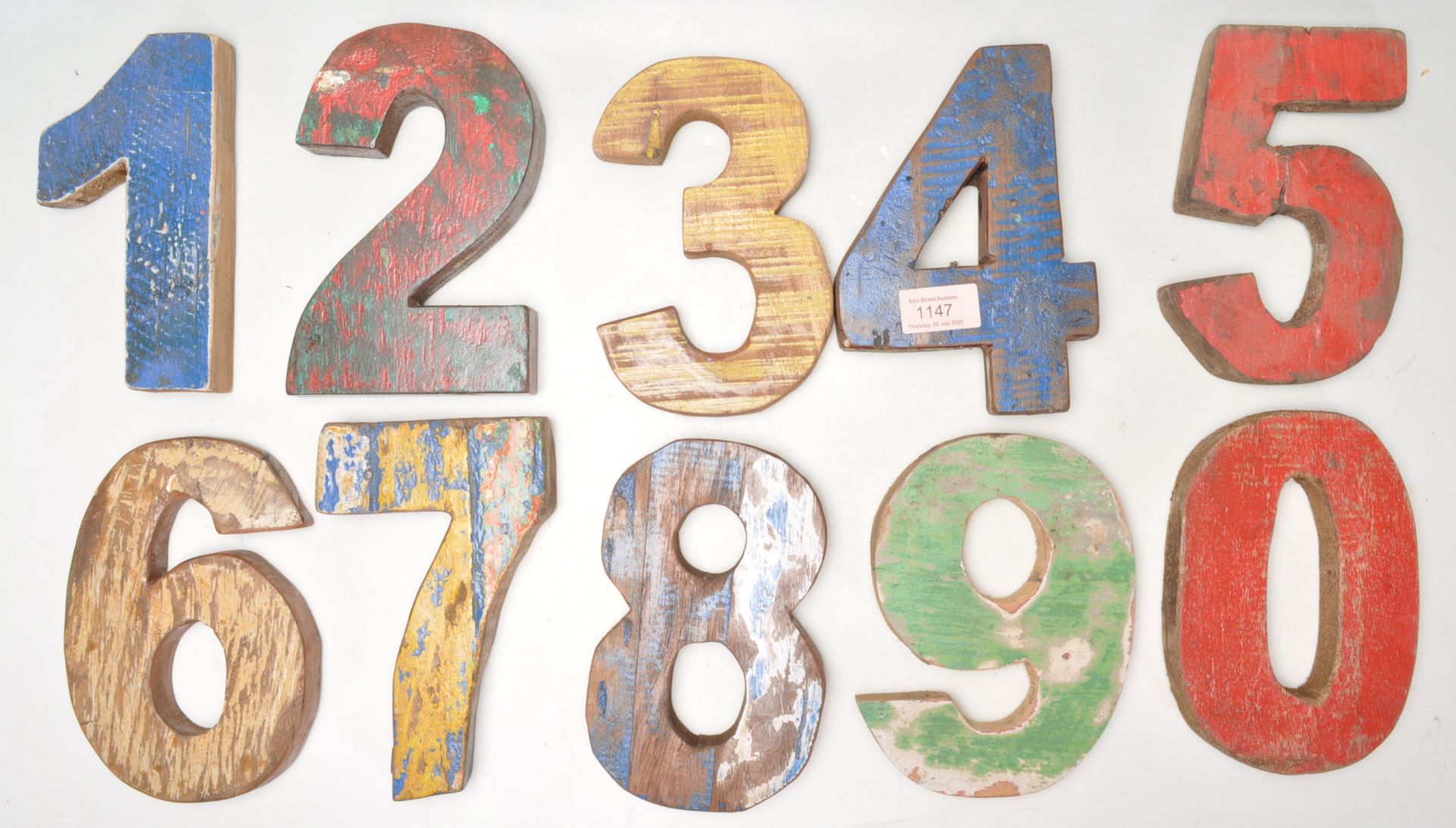 A set of vintage retro wooden signage numbers each having weathered different coloured paintwork