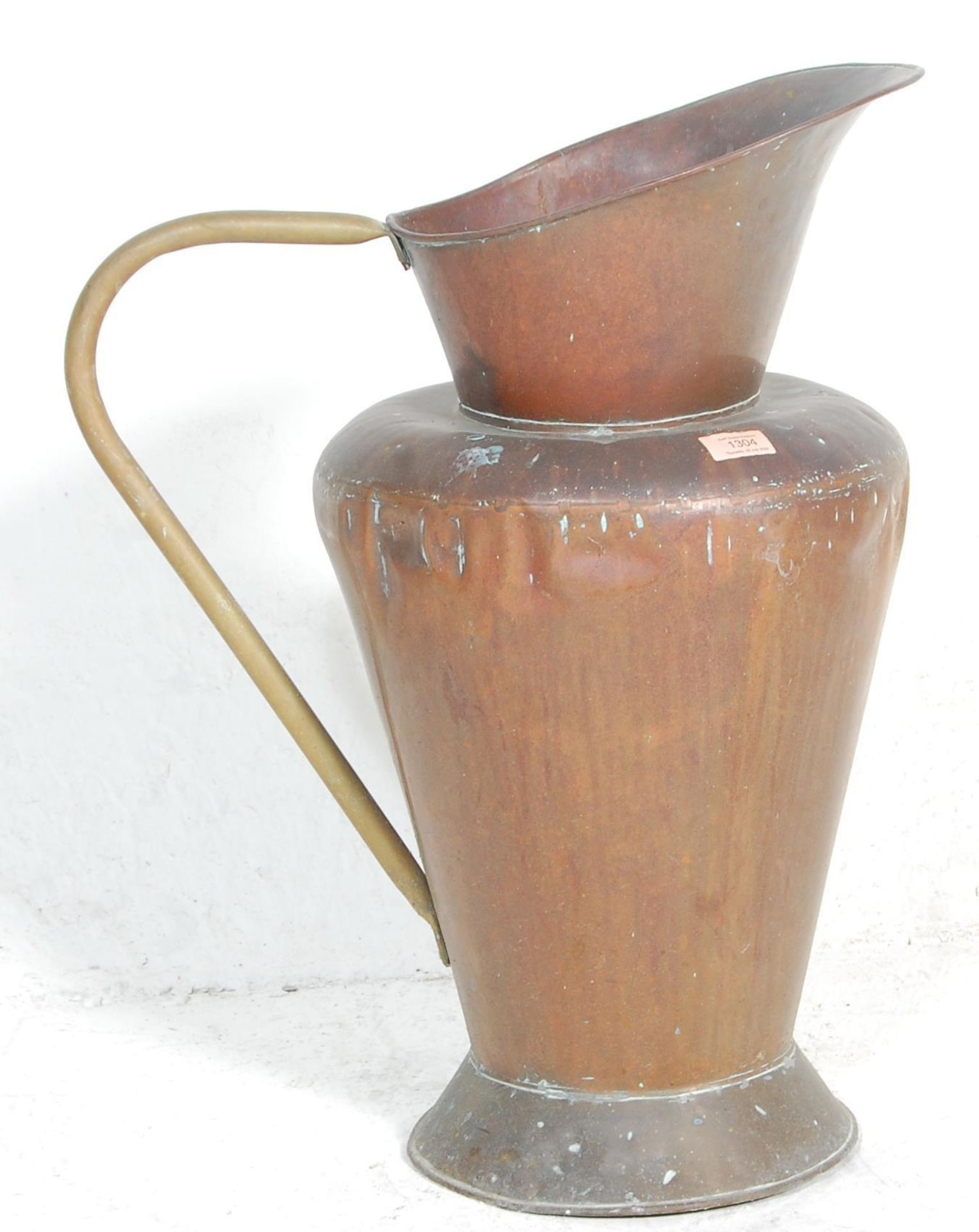 A late 19th / early 20th Century large copper jug having a tapering body with a round base and