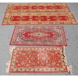 A collection of 4 20th century Persian / Islamic floor rugs. All with red grounds and tassled