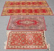 A collection of 4 20th century Persian / Islamic floor rugs. All with red grounds and tassled