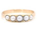 A 9ct gold and half pearl ring. The ring ( unmarked but tests as 9ct) with 5 channel set half