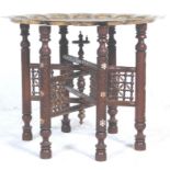An early 20th Century Indian brass topped Benares table  having a scalloped edge top with