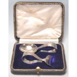 A silver hallmarked spoons and pusher set having empty cartouche handles. Both let within original
