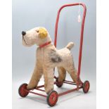 A vintage 20th Century Chiltern made push / ride along dog fixed to a tubular red painted metal