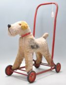 A vintage 20th Century Chiltern made push / ride along dog fixed to a tubular red painted metal