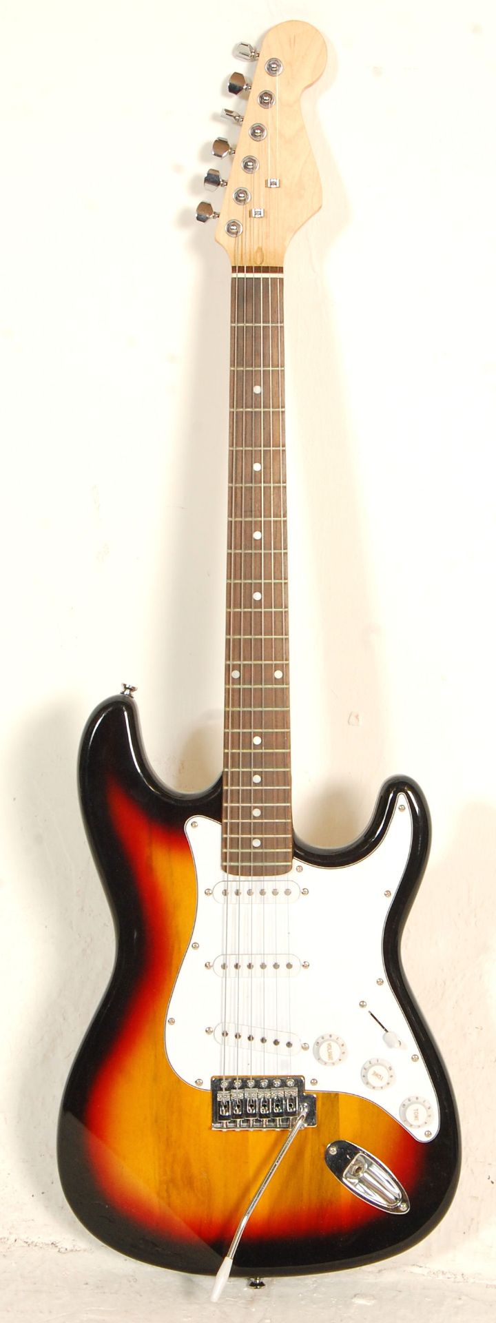 A good Fender Stratocaster style six string electric guitar having three control knobs with a