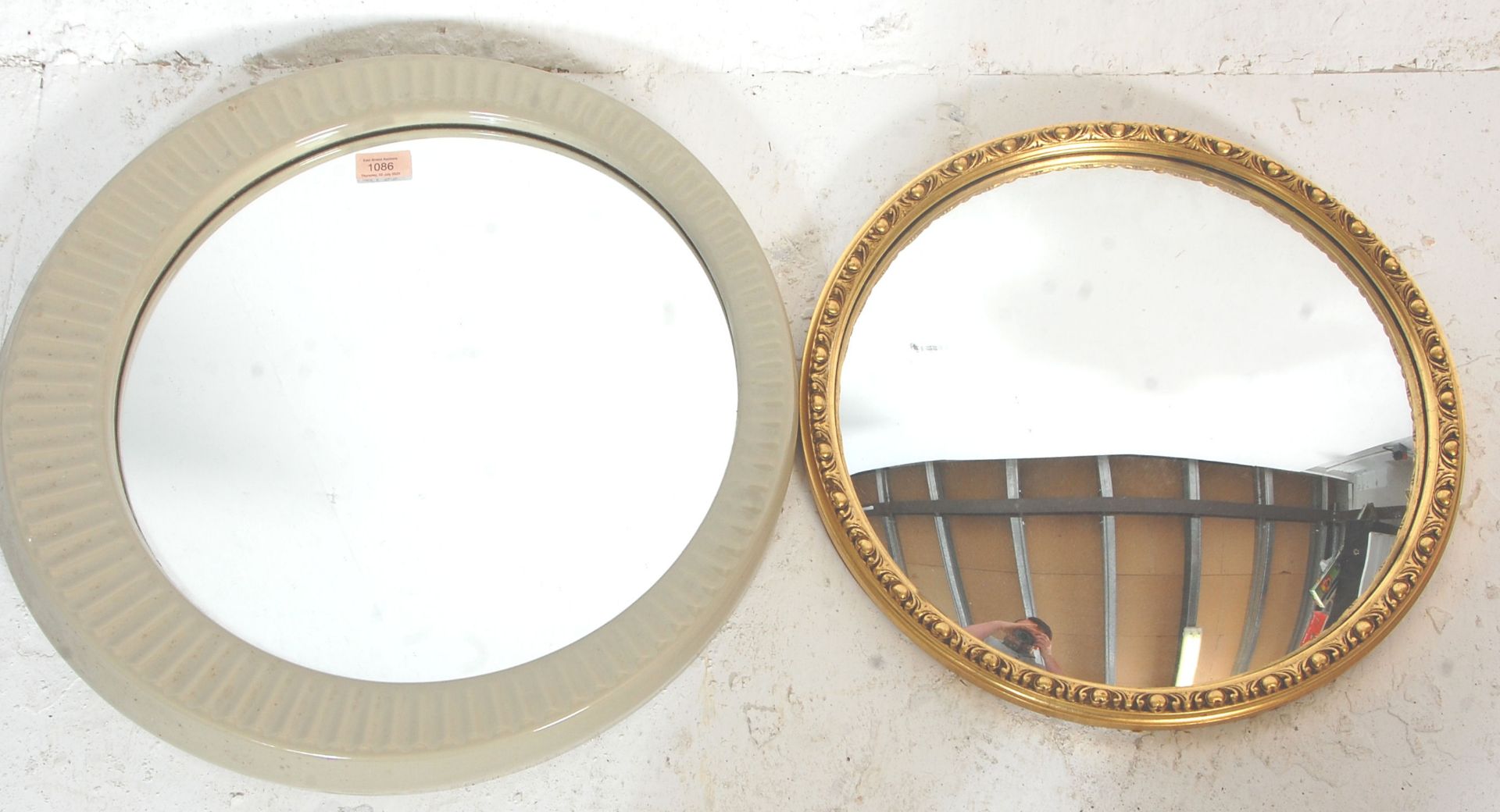 A vintage retro mid 20th Century wall mirror of round form having a ceramic cream coloured famed