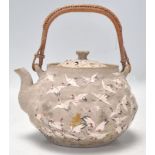 An unusual Chinese hand painted terracotta teapot being decorated with a grey ground highly detailed
