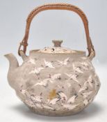 An unusual Chinese hand painted terracotta teapot being decorated with a grey ground highly detailed