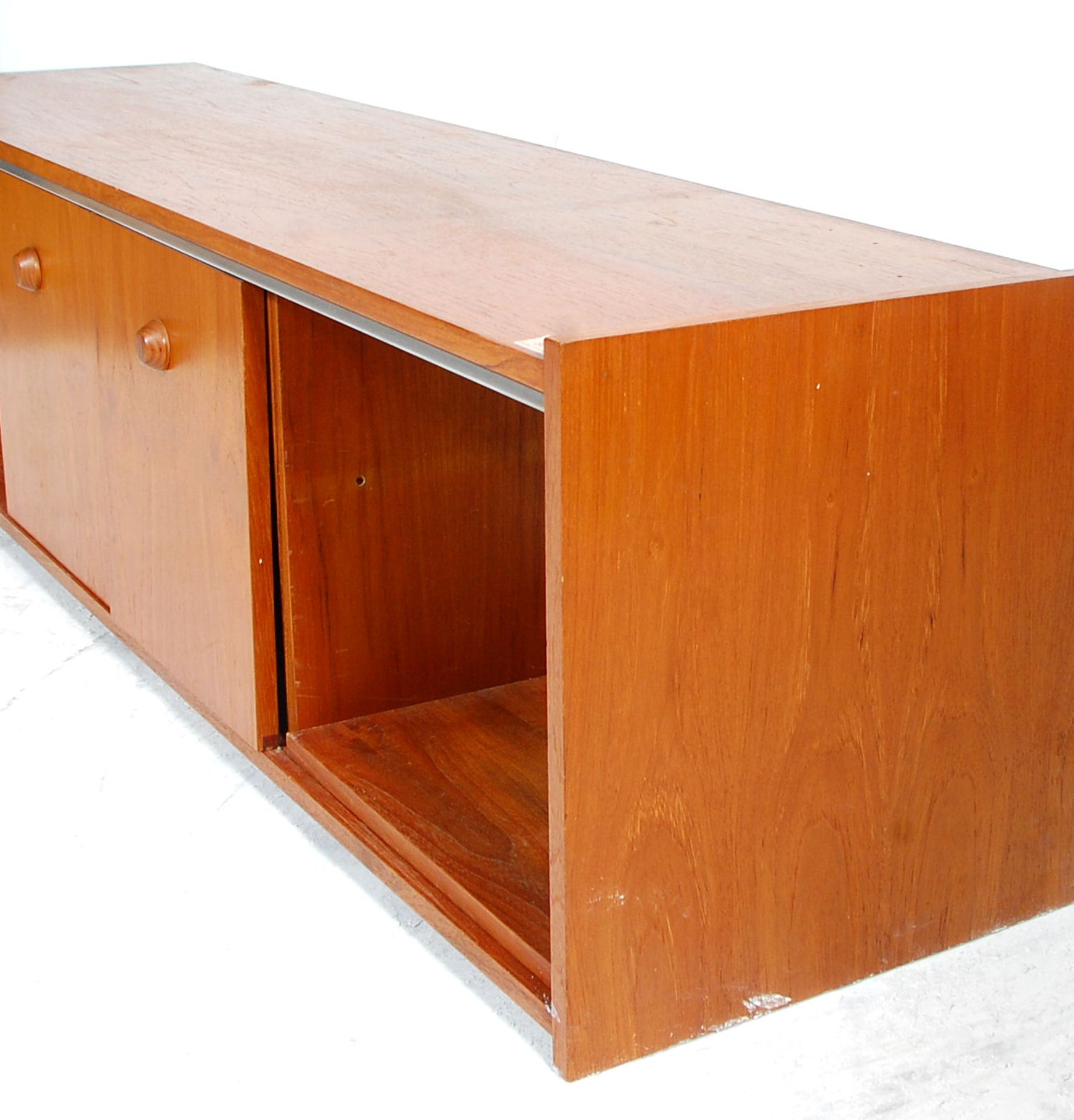 A low mid 20th Century retro teak wood unit / sideboard having sliding doors across open sections - Bild 3 aus 5