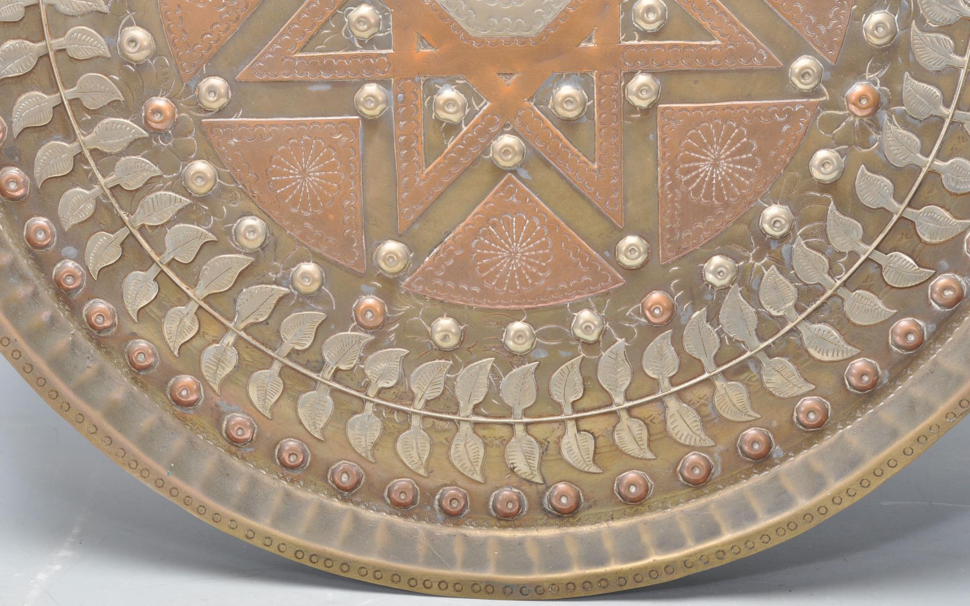 A 20th Century Middle Eastern brass and copper wall charger of circular form having inlaid white - Bild 4 aus 8