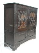 A Jacobean revival ebonised oak double door astragal glazed bookcase with butterfly hinges set