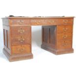 An early 20th Century oak pedestal office / library desk having a green leather top with three