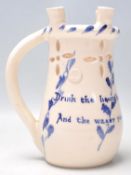 An early 20th century mottoware puzzle jug in blue and white colourway having notation ' Drink the