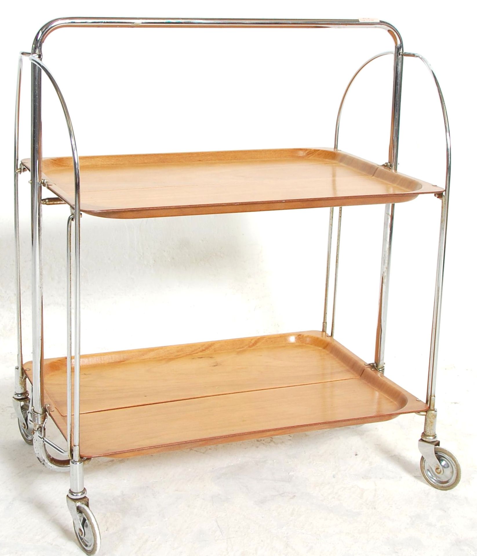 A retro mid 20th Century chrome and wooden trolley by Gerlinol Brenshey Dinett. Raised on original