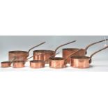 A good graduating set of eight 19th Century Victorian copper pans having riveted metal handles.