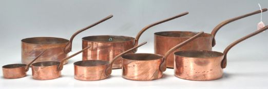 A good graduating set of eight 19th Century Victorian copper pans having riveted metal handles.