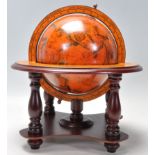 A Georgian style terrestrial desk globe supported in a wooden meridian ring and a finely decorated