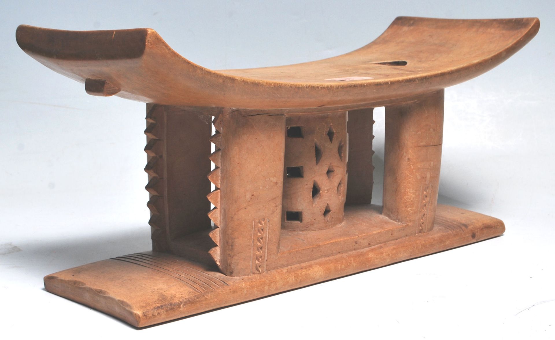 A carved African tribal Akan / Asante Ghanaian anthropomorphic stool having a rectangular curved