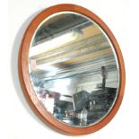 A vintage retro mid 20th Century circular teak framed hanging wall mirror having a bevelled edge