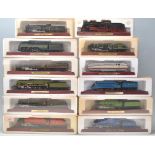 A group of twelve boxed 00 Gauge model trains on wooden plinth bases to include The Flying Scotsman,