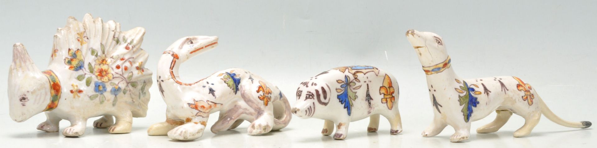 A group of four antique French quimper faience pottery animal figurines, each being hand painted