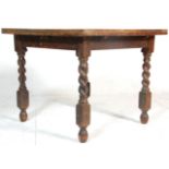 An early 20th Century draw leaf refectory dining table raised on block and barley twist supports