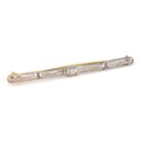 An 18ct gold, platinum and diamond Art Deco bar brooch. The pin having an open work design set