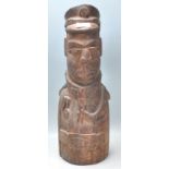 An unusual carved wooden African tribal figurine in the form of a uniformed officer, with cap to the
