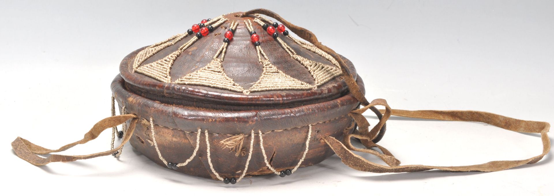 An early 20th Century Vintage tribal Ethiopian injera bread basket. Leather covered with beadwork