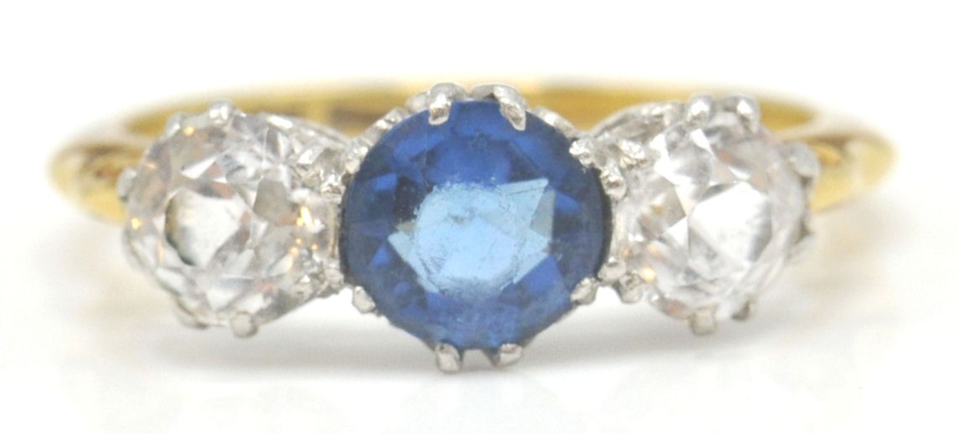 An Edwardian period 18ct gold and platinum 3 stone ring. The ring set with 3 paste stones of round