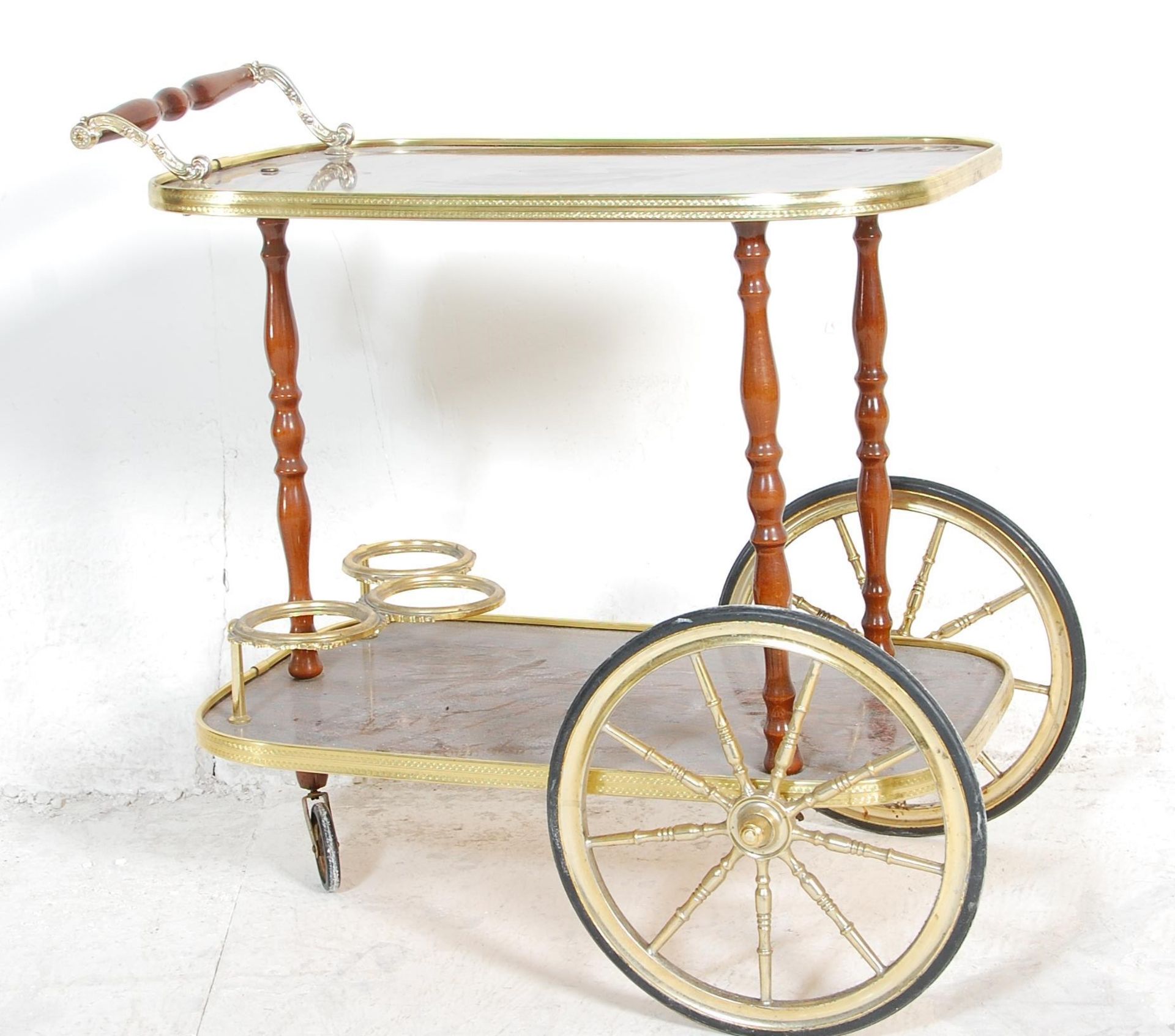 A vintage retro two tier Italian style drinks trolley, brass gallery surround to each tier raised on