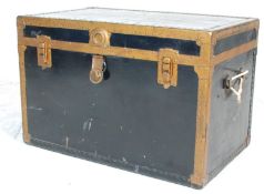 A late 19th / early 20th Century travelling trunk of ebonised construction gilt gilt brass banding