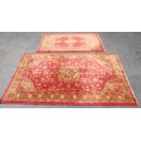 A pair of matching  20th century Persian / Islamic floor rugs. Both with red grounds and tassled