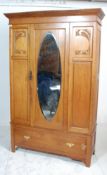 An early 20th Century Edwardian oak single door wardrobe having carved Art Nouveau floral