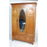 An early 20th Century Edwardian oak single door wardrobe having carved Art Nouveau floral