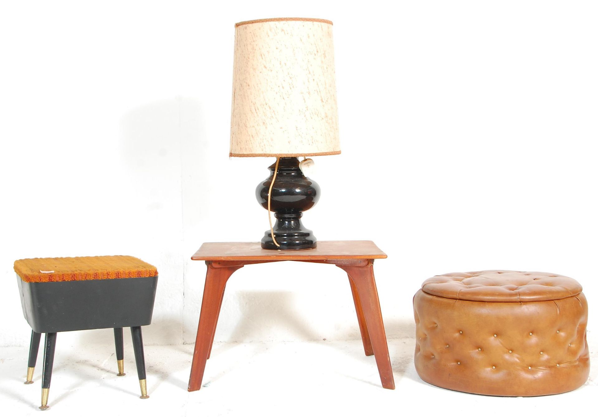 A retro mid 20th Century sewing stool having a orange fabric lift up lid and black rexine covered