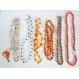 A mixed group of jewellery to include faux amber necklaces, croal and white metal Tibetan