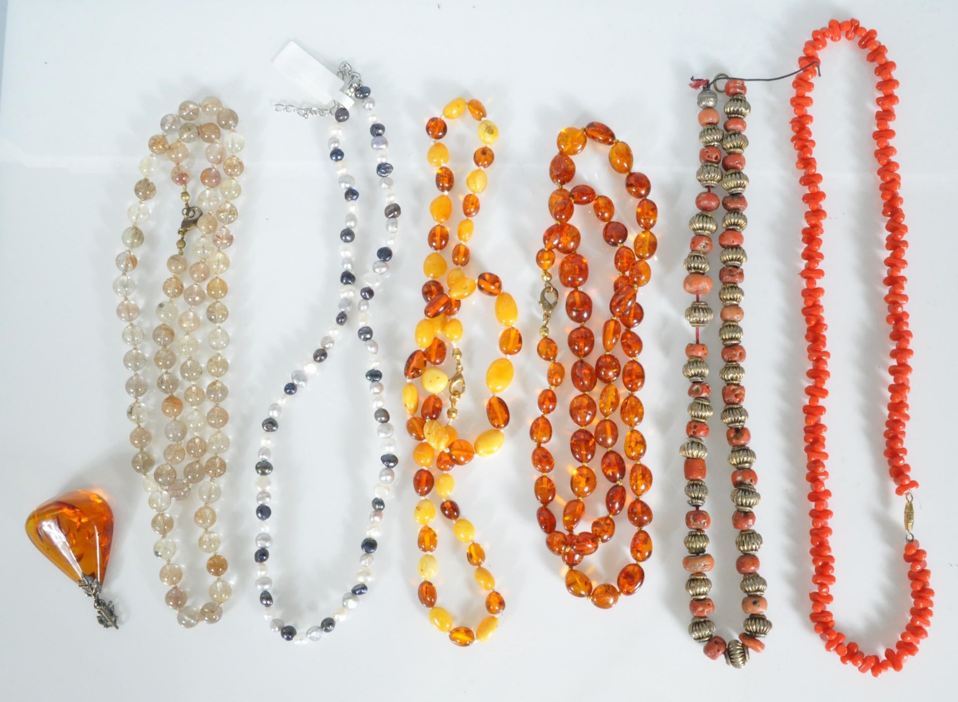 A mixed group of jewellery to include faux amber necklaces, croal and white metal Tibetan