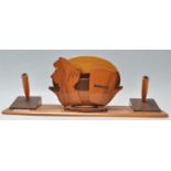 A retro mid century teak wood desk tidy of unusual form. Raised on a plinth base with a central